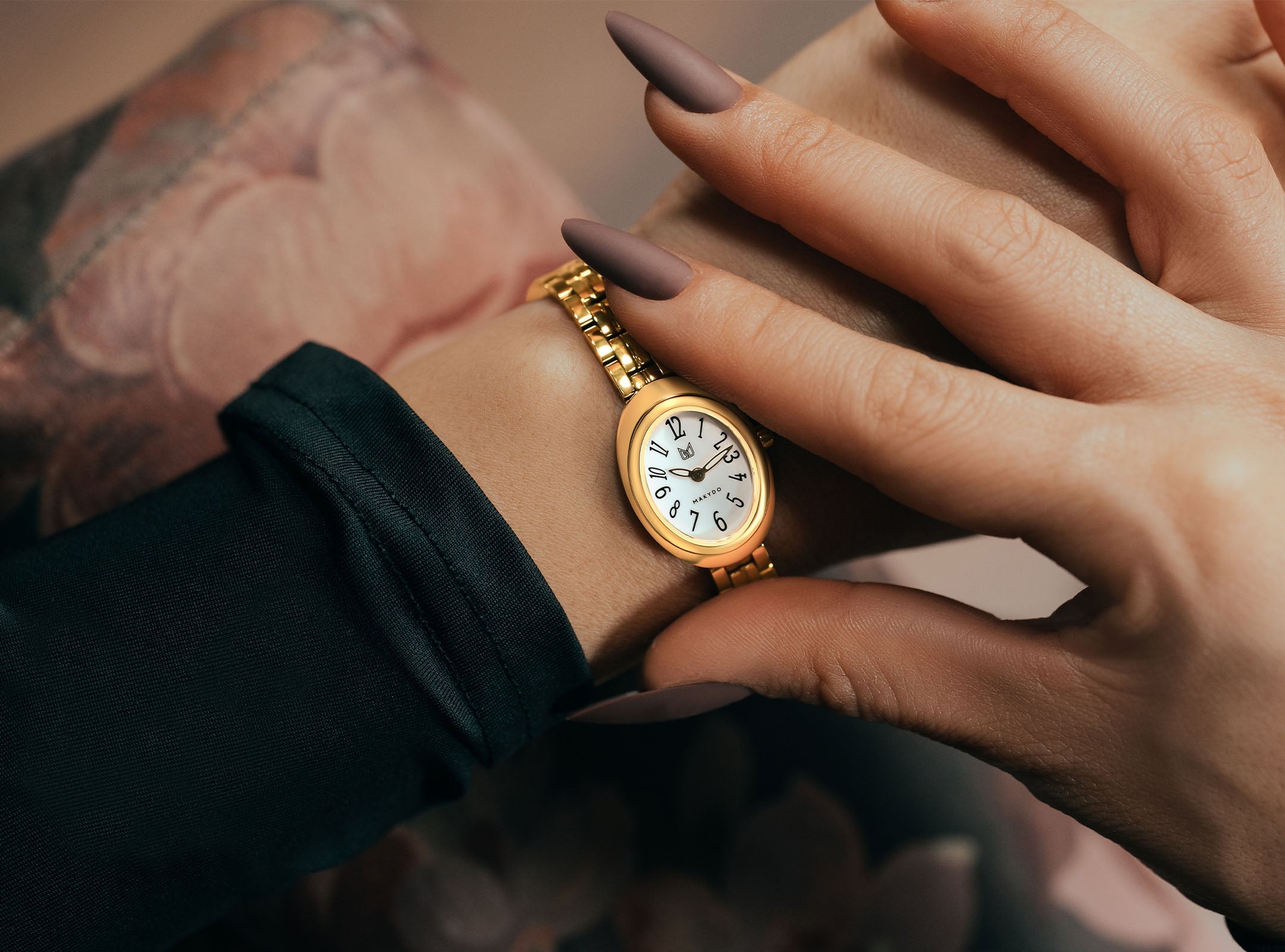 Woman wearing Noor Luna 27mm oval gold women’s dress watch with white dial