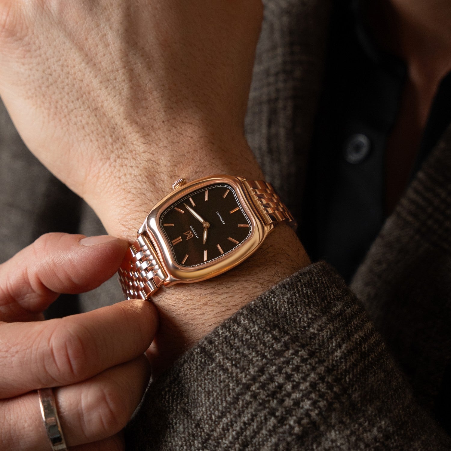 Rose gold watch on a wrist with a blurred background