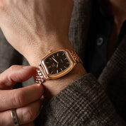 Rose gold watch on a wrist with a blurred background
